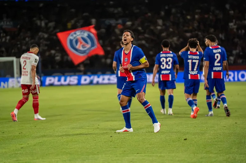 Un attaquant parisien lève les bras devant la tribune après son but